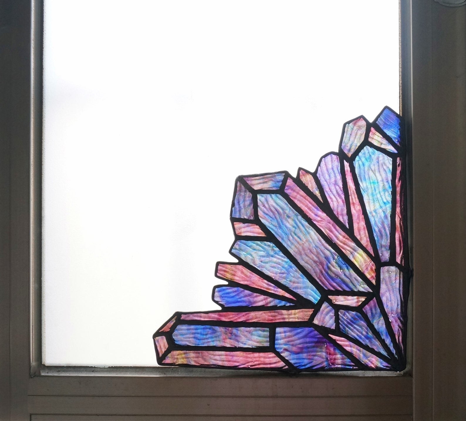 the iridescent glass crystal corner piece in the corner of a window