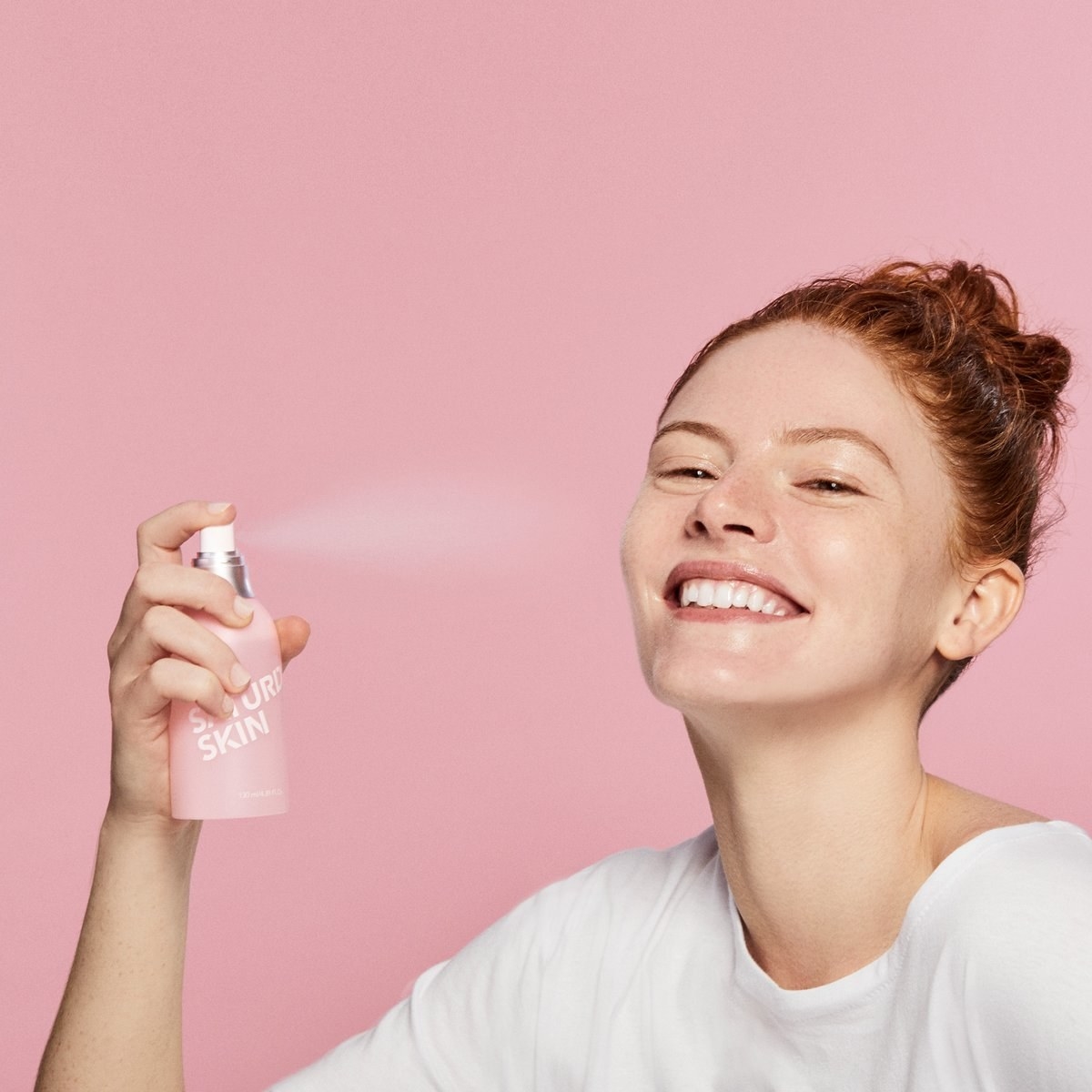 model spraying the bottle on her face