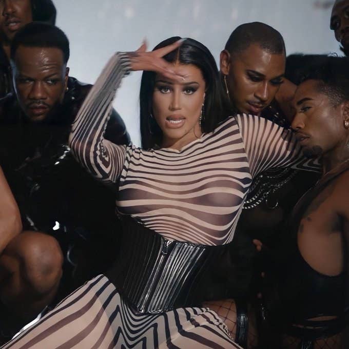 Iggy Azalea with long, straight dark hair amid backup dancers