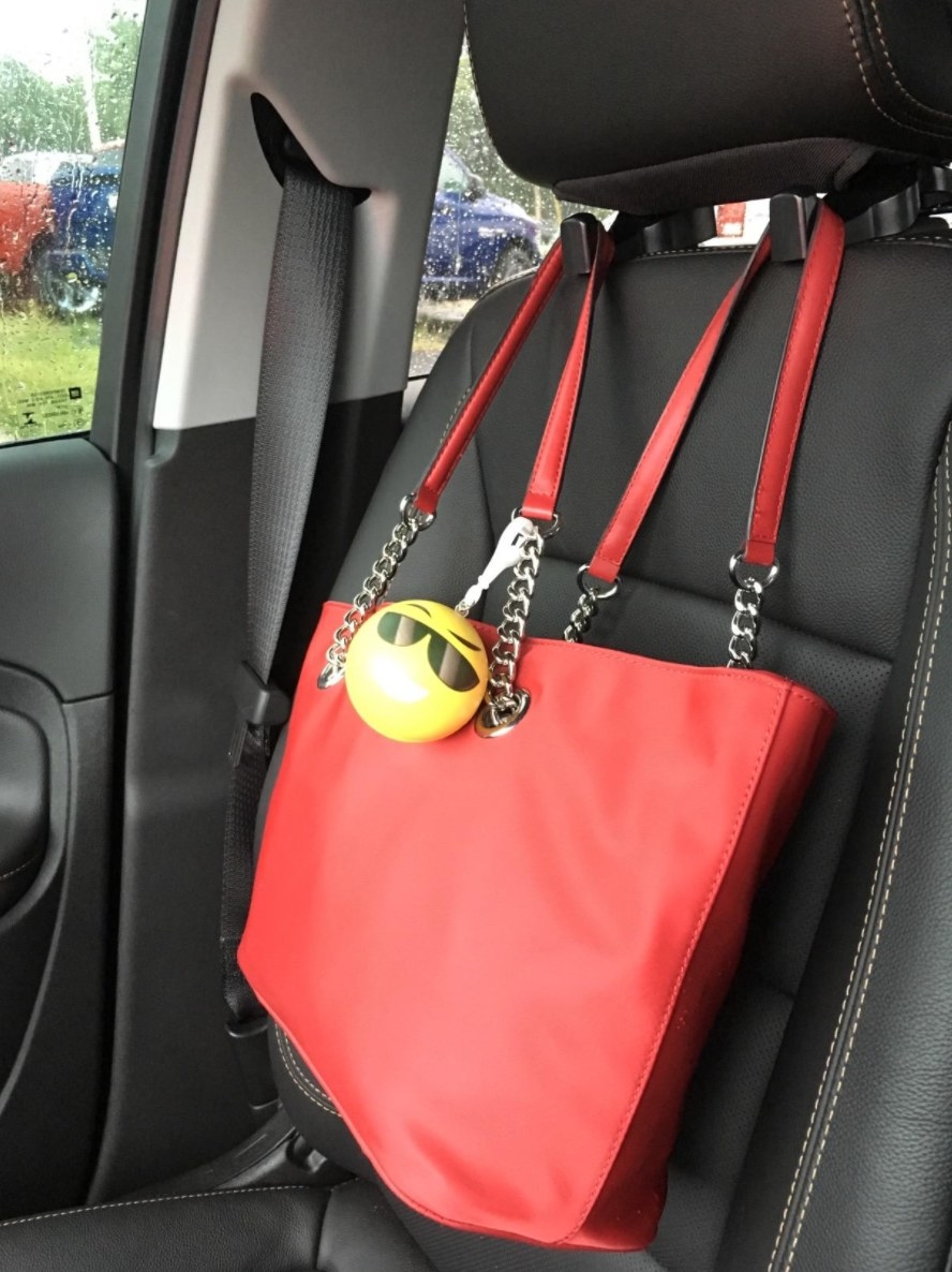 the headrest hook holding a red purse