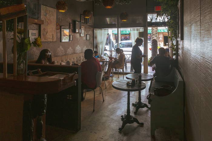 Tables of people sit inside a cafe