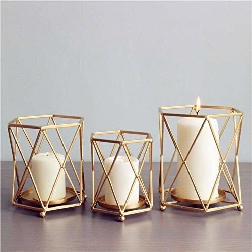 Three geometric candle holders with candles in them