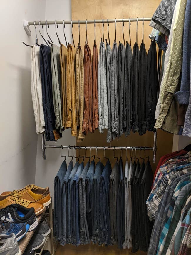 reviewer's closet with pants hung on the top and bottom of the adjustable closet rod