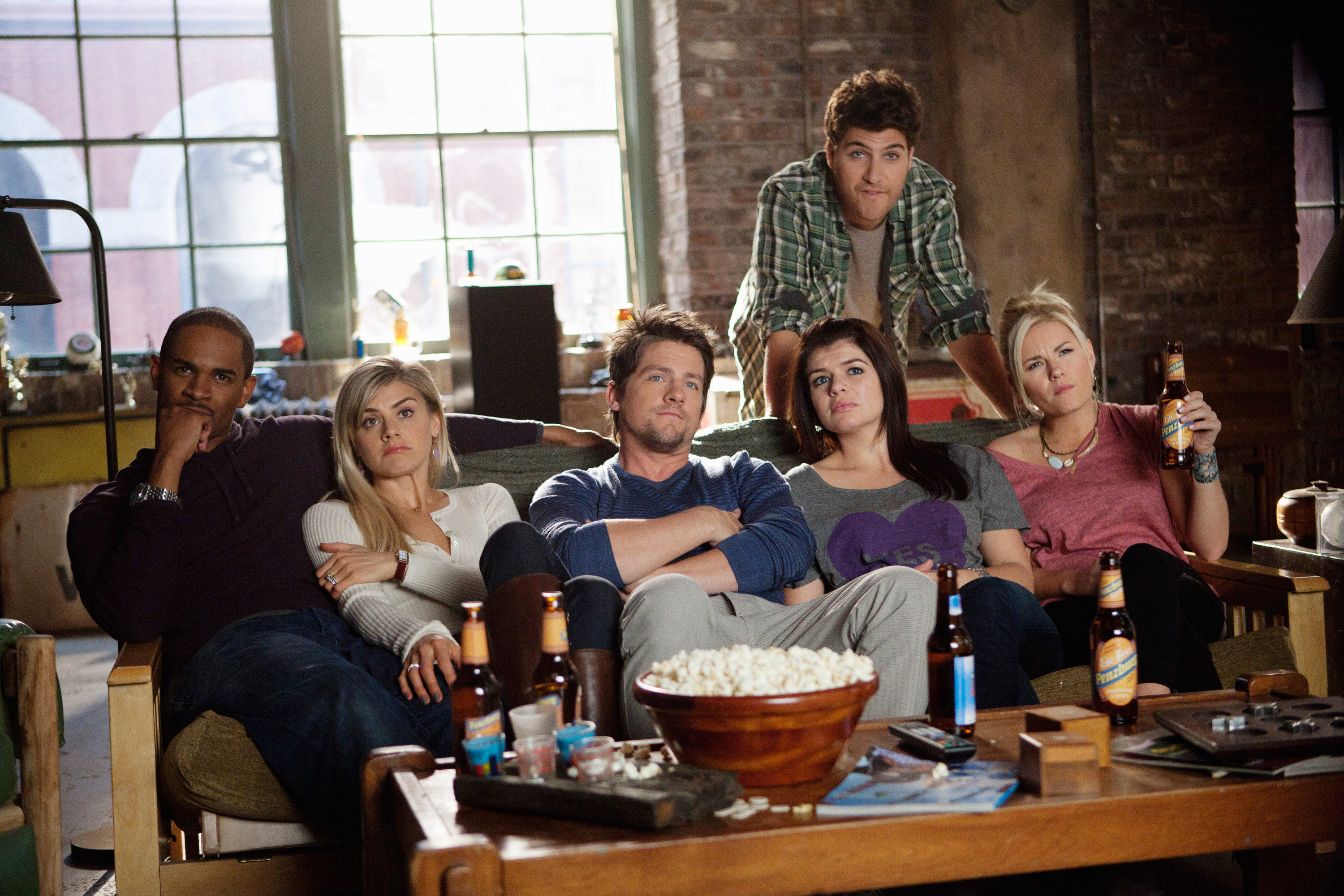 Damon Wayans Jr., Eliza Coupe, Zachary Knighton, Casey Wilson, Adam Pally, and Elisha Cuthbert sitting on the couch drinking beer as Brad, Jane, Dave, Penny, Max, and Alex on &quot;Happy Endings&quot;