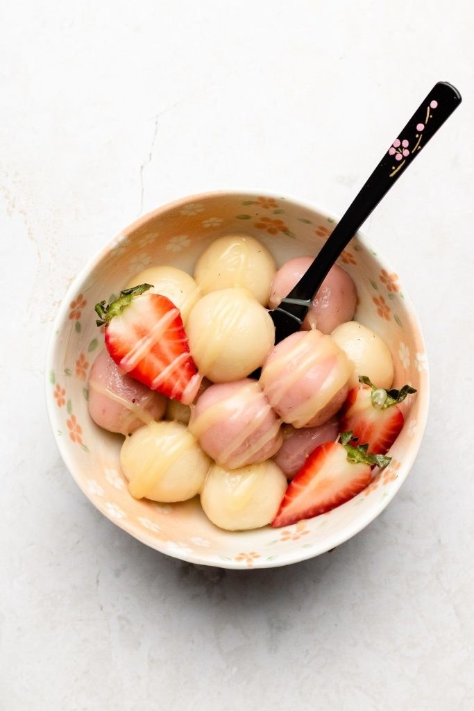 Bowl filled with Shiratama Dango balls and sliced strawberries, drizzled with condensed milk.