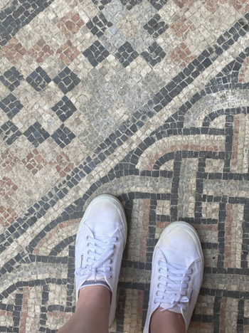 Buzzfeed editor Elizabeth Lilly's feet in Supergas shoes standing on mosaic floor