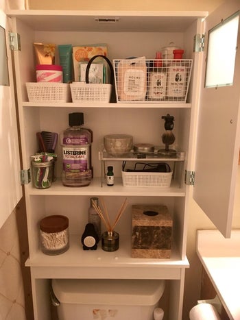 another reviewer image making use of all the shelves inside with multiple, well organized baskets full of toiletries