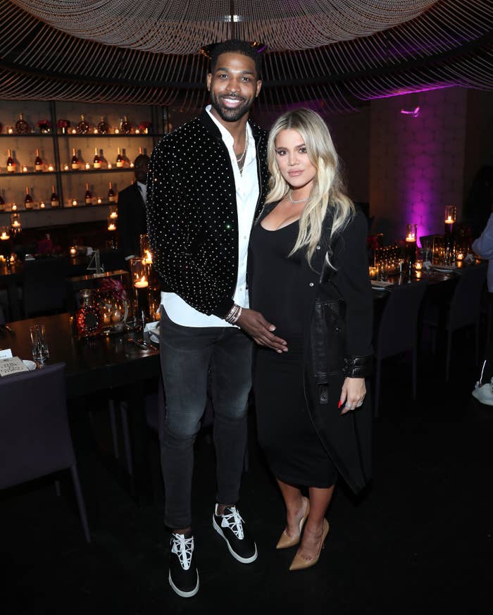 Tristan Thompson cradling Khloe&#x27;s baby bump while they pose for a photo