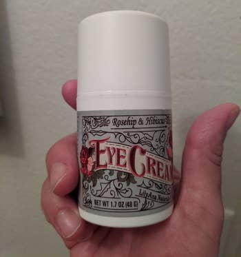 the bottle of eye cream in a reviewer's hand