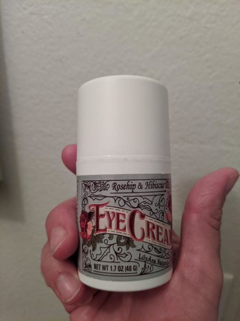 the bottle of eye cream in a reviewer's hand