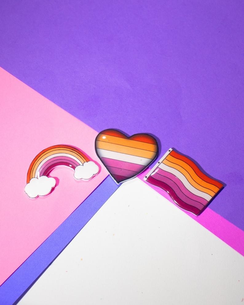 lesbian rainbow, heart, and pride flag themed pins