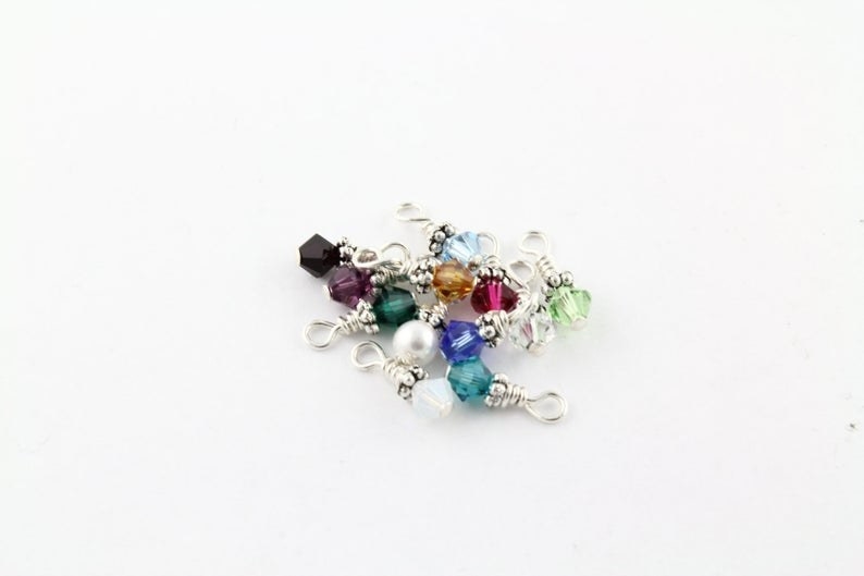 12 small birthstone charms in a pile