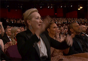 Meryl street standing up, clapping, and pointing at the oscars