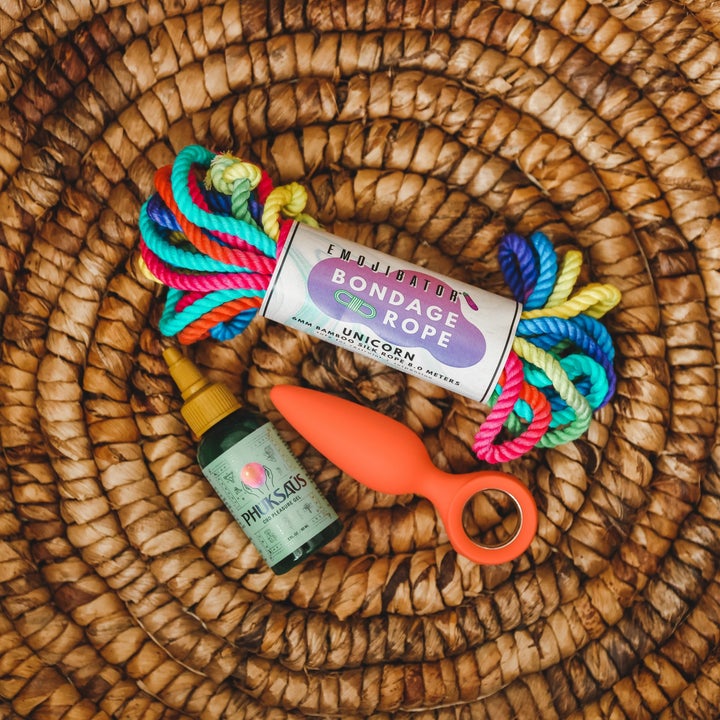 Unicorn bondage rope, orange vibrating anal plug and brown bottle of CBD lubricant