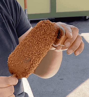 dipping the corn dog in the peanut butter