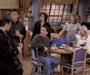 Joey, Chandler, Ross, Monica, Rachel, and Phoebe all smiling and clapping