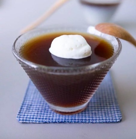 Glass with coffee jelly topped with whipped cream.