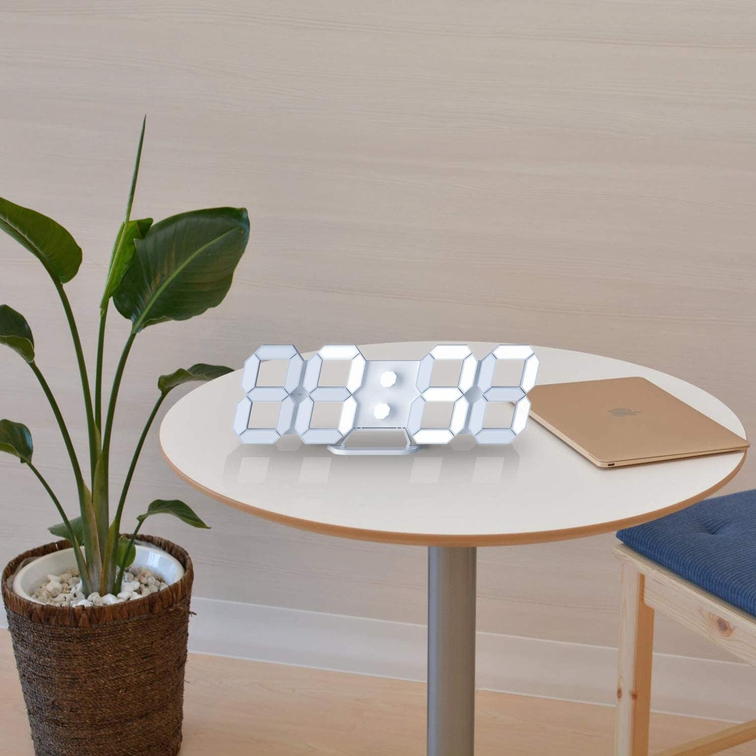 The clock on a table next to a plant