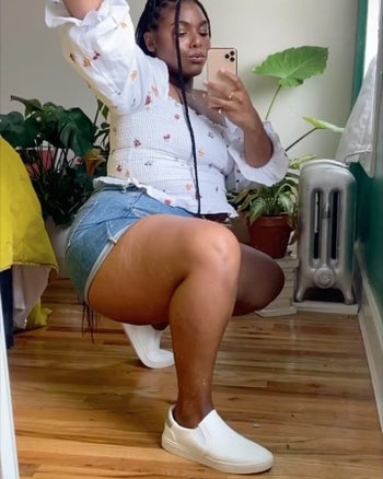 reviewer mirror selfie squatting, wearing the white slip-ons