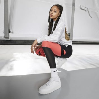 model squatting wearing the Air Force 1s sage lows