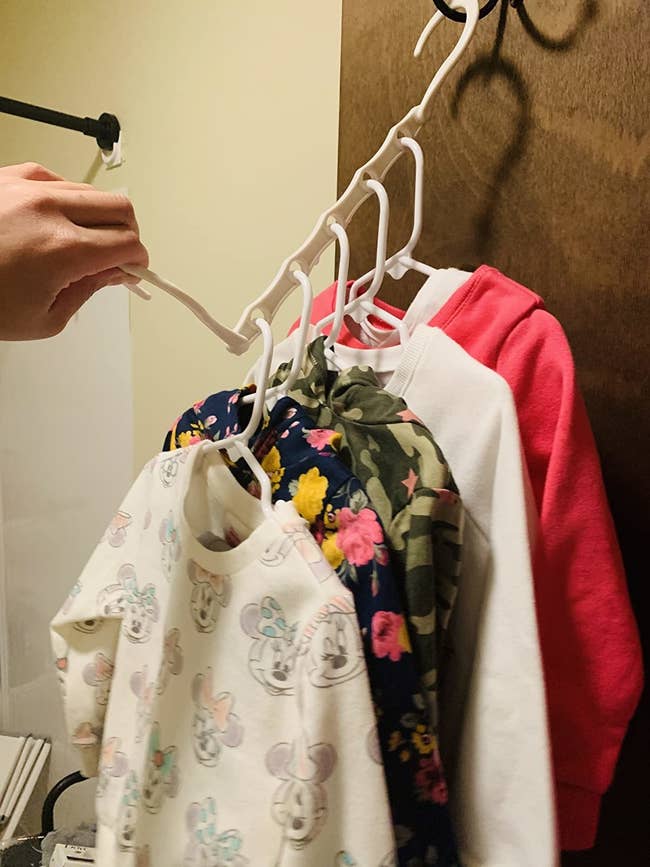image of reviewer hanging baby clothes vertically using the closet organizer