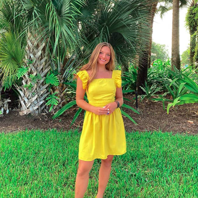 A customer review photo of them wearing the dress in yellow
