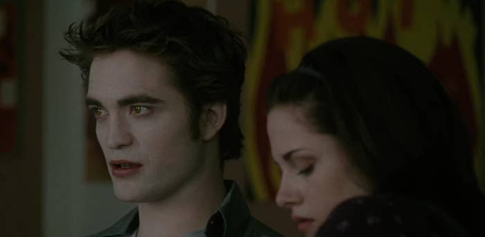 Edward staring ahead, sideburns on full display, with Bella sitting next to him