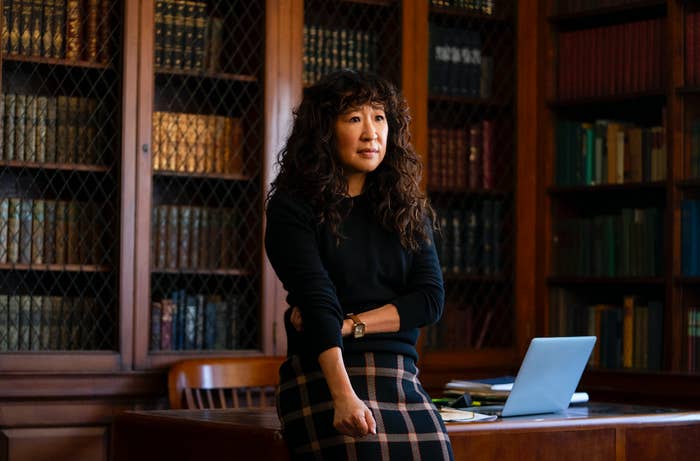 Sandra Oh leaning against a desk