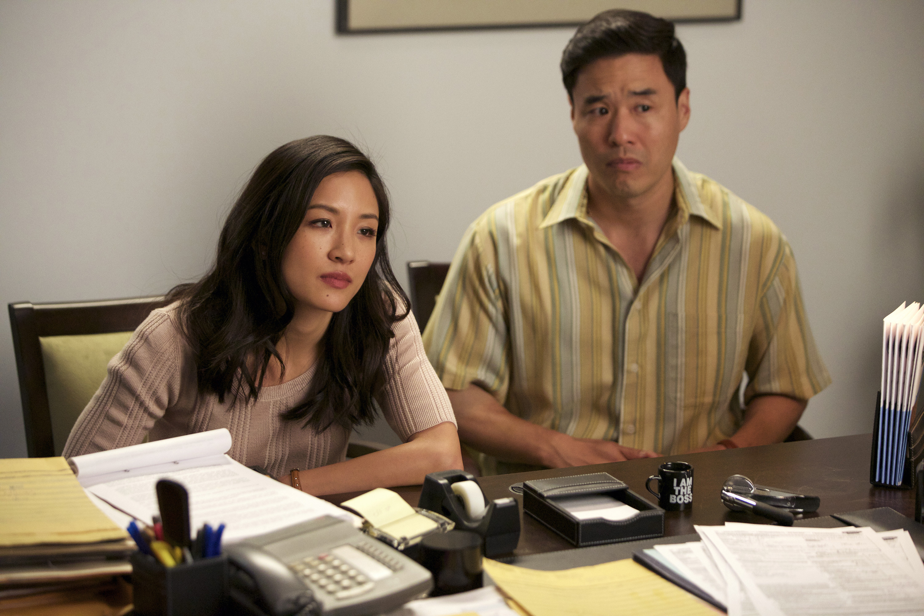 Constance Wu and Randall Park as the parents in the series in an office