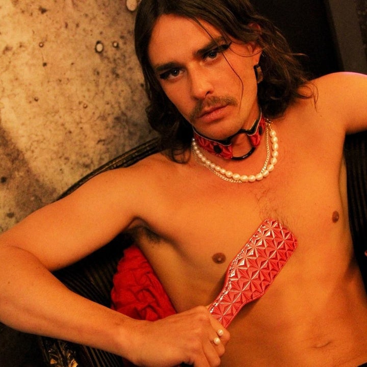 Model holding pink textured paddle against torso