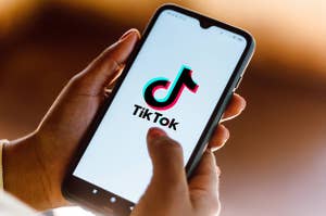 Hands holding a phone open to TikTok
