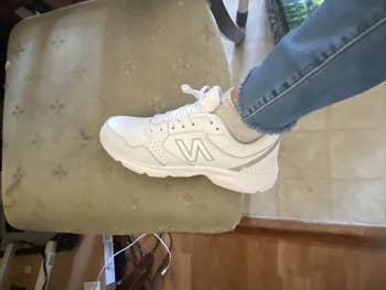 reviewer photo of one foot wearing the white New Balance sneakers
