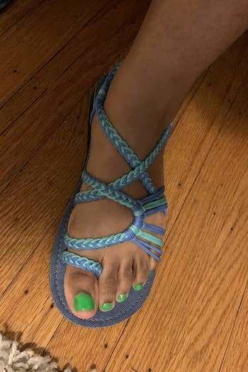 a reviewer wearing the sandals in blue and green 