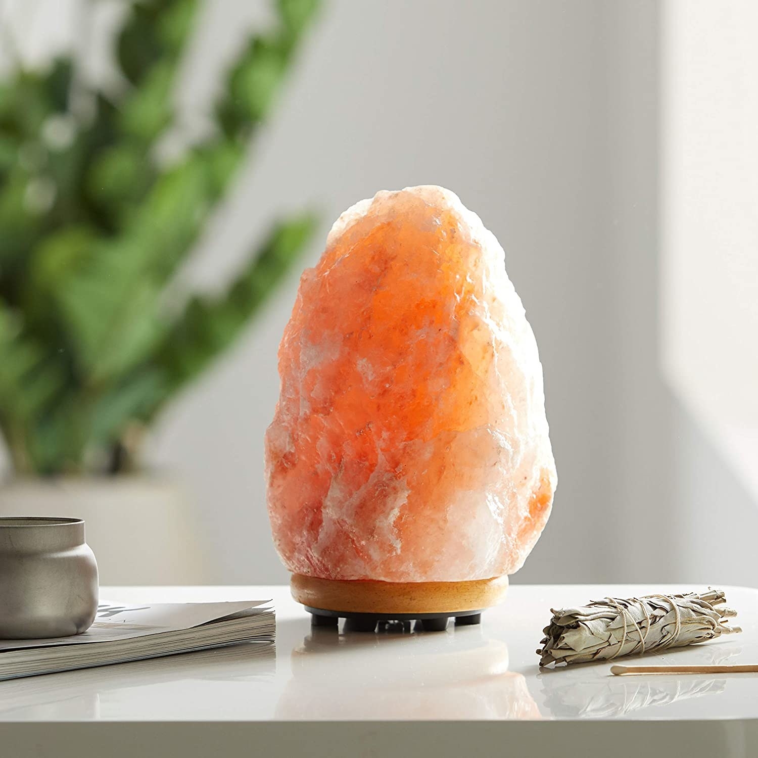 A Himalayan salt lamp in a pinkish hue placed on a table