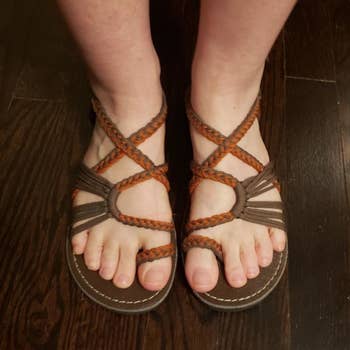 a pair of reviewer's feet in the sandals in brown