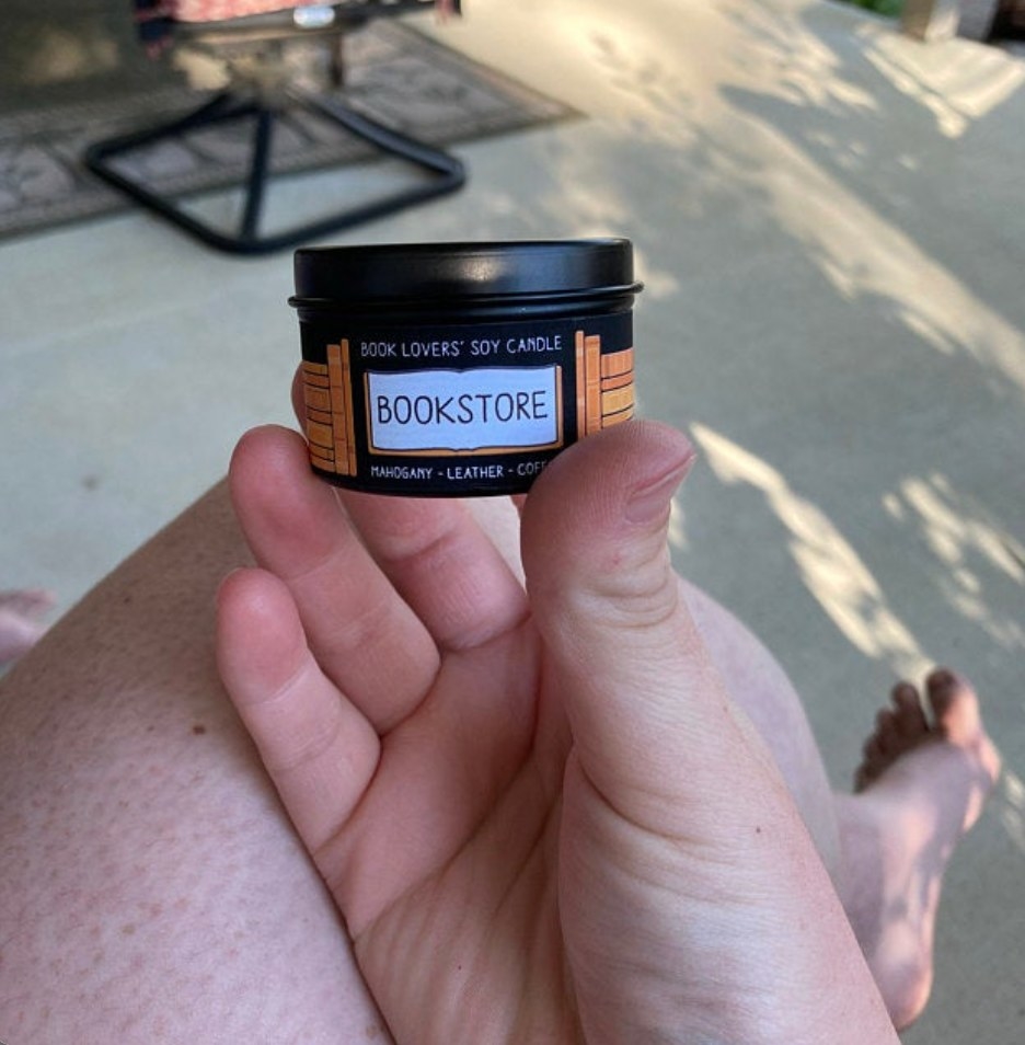 the book lovers&#x27; soy candle being held by a reviewer