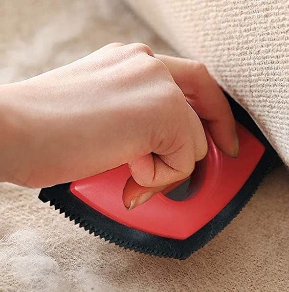A person scraping their couch with the tool