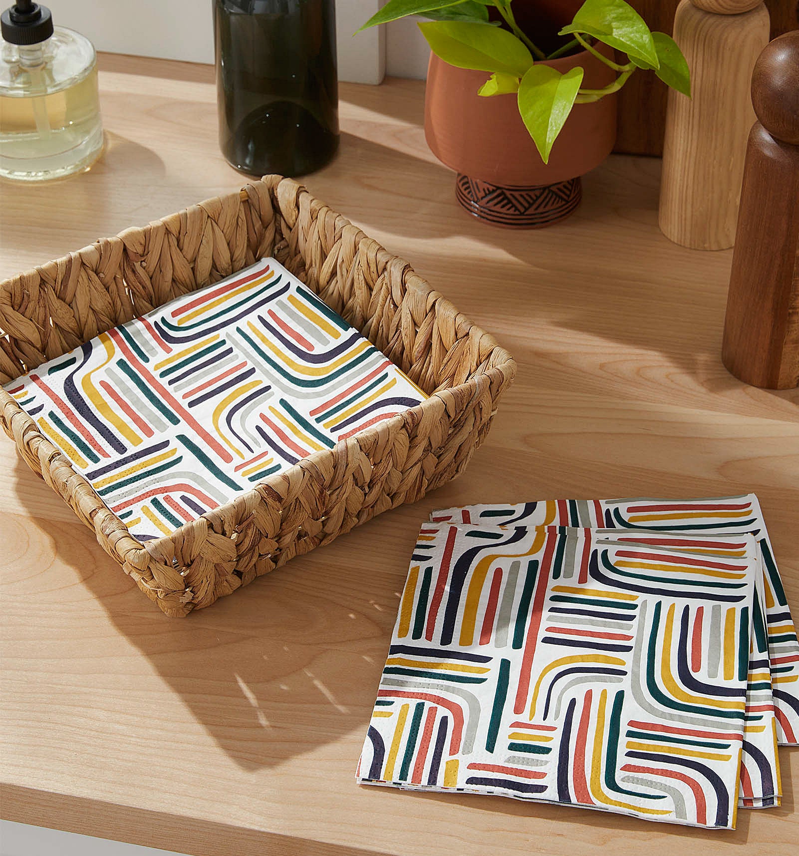 Vibrant paper napkins in and beside a cute basket on a counter