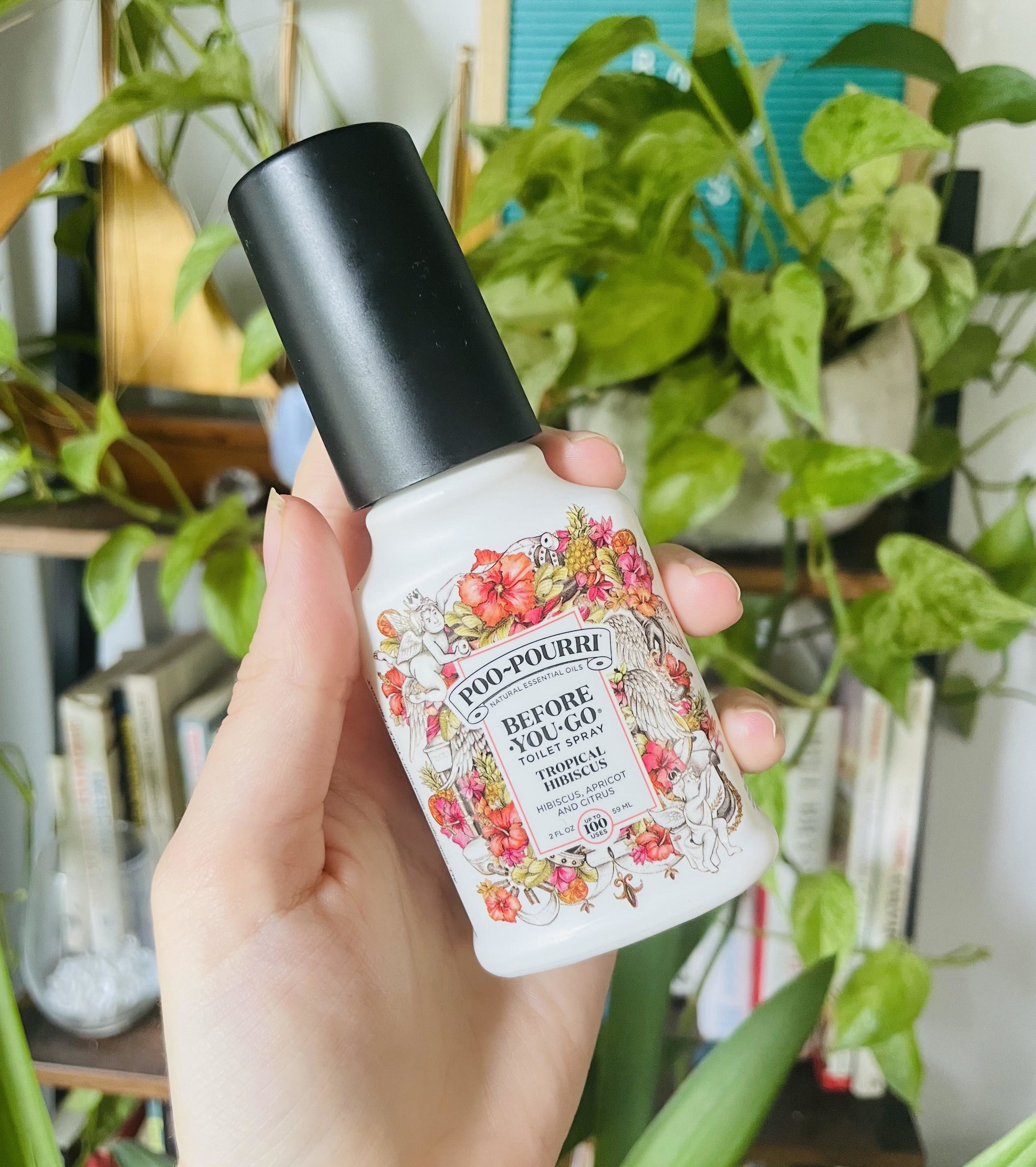 A person holding the bottle of Poo-Pourri spray