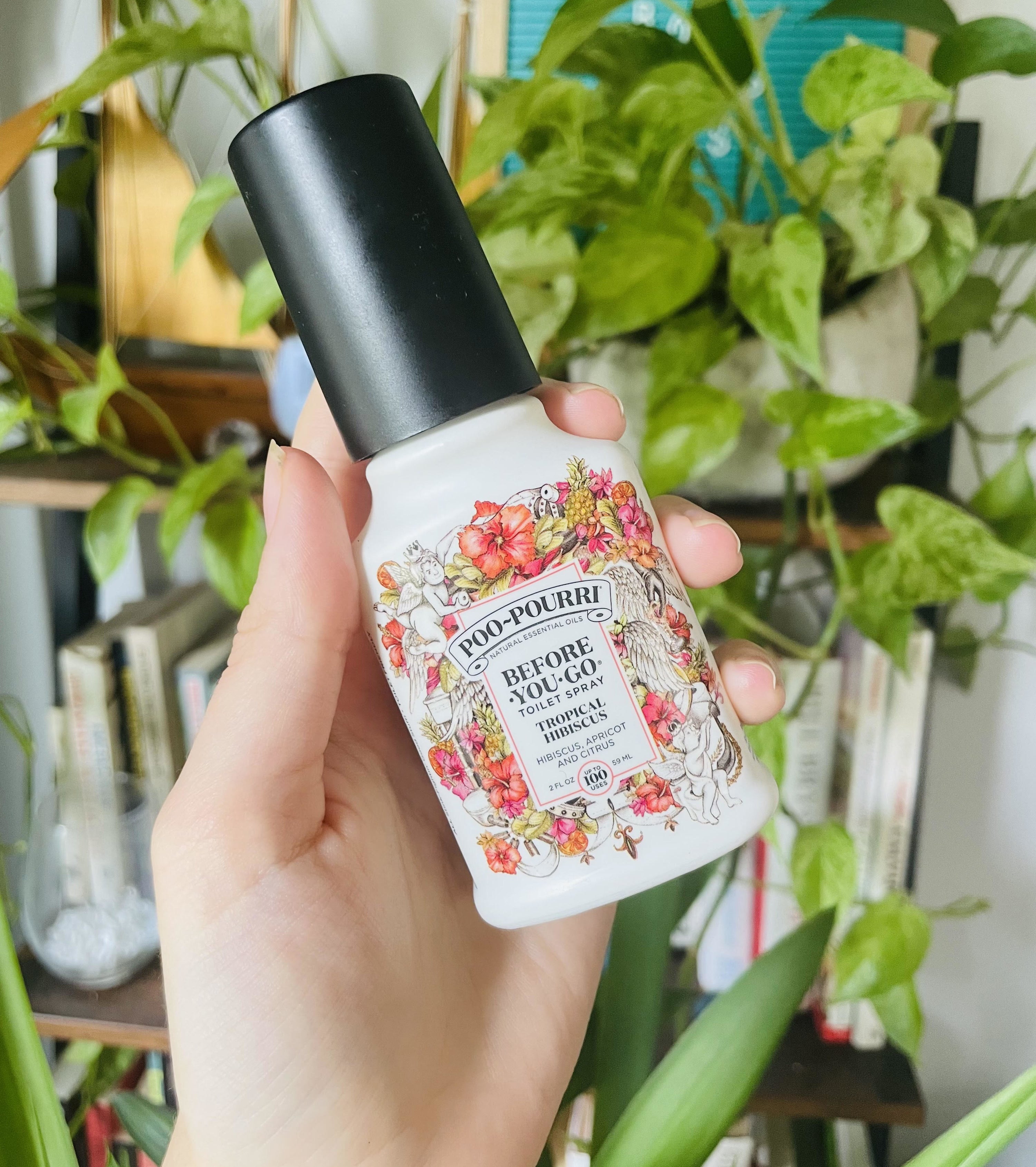 A person holding the bottle of Poo-Pourri spray
