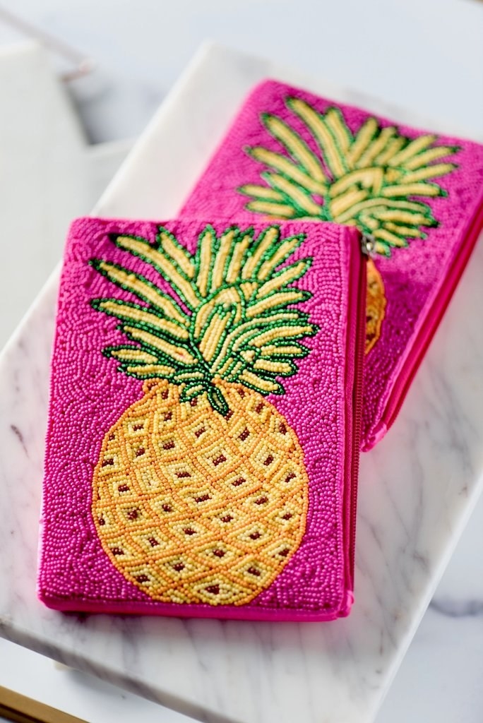 two pineapple mini clutches on a marble surface