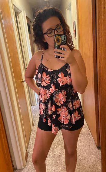 reviewer wearing the coral floral top and black short set