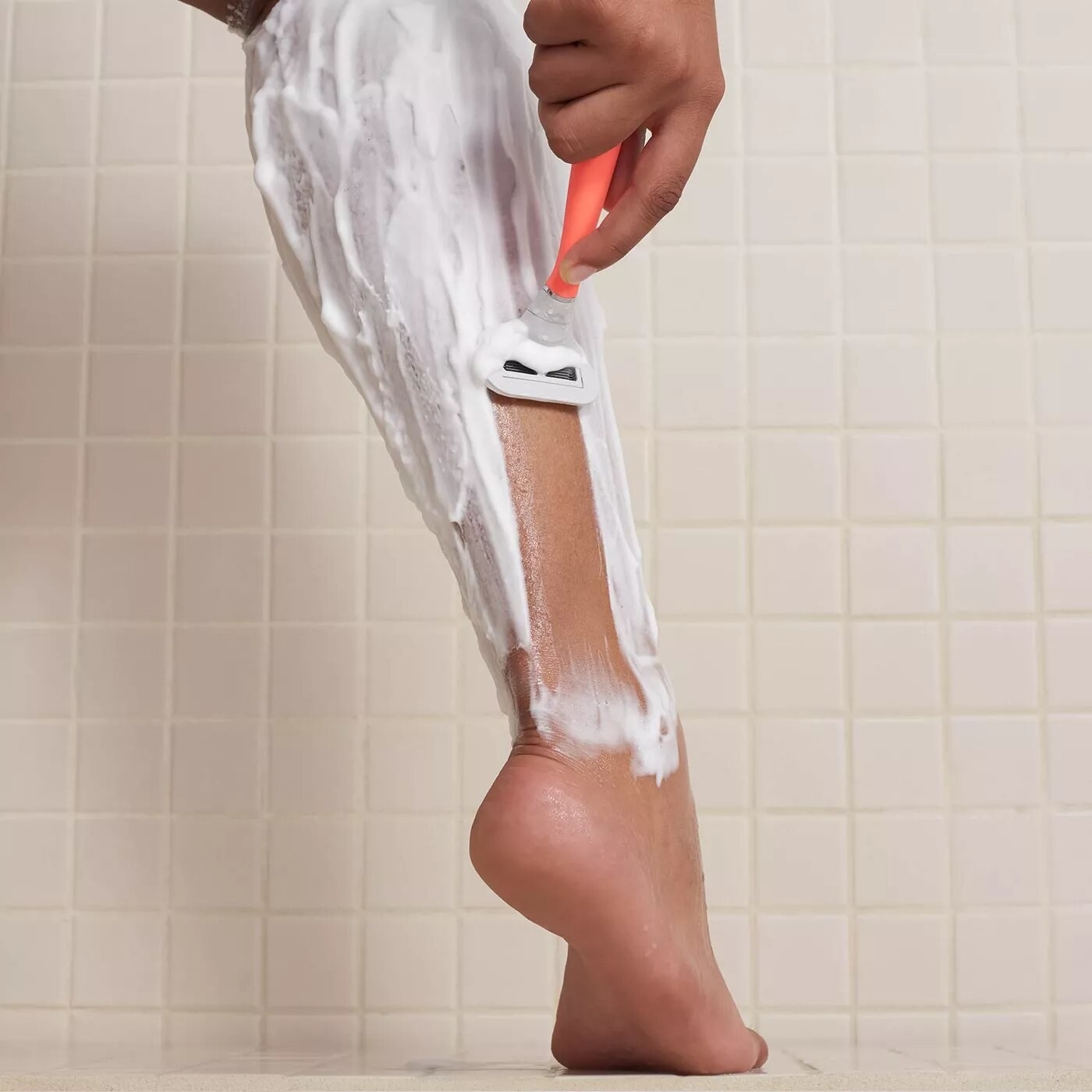 person shaving legs with flamingo razor