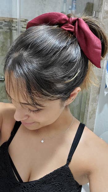 ribbon in red on reviewer's ponytail 