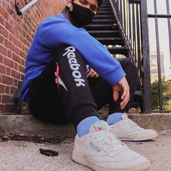 Instagram photo of model wearing a black face mask and the Reebok C85s with Reebok pants