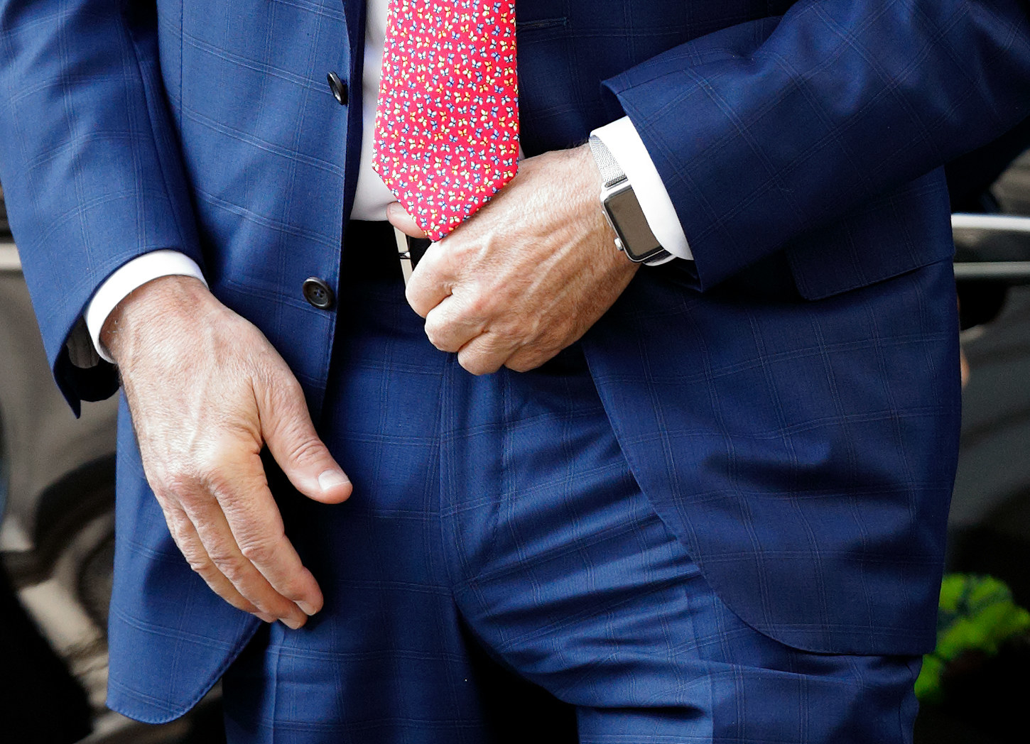 A man in a suit wearing an Apple Watch