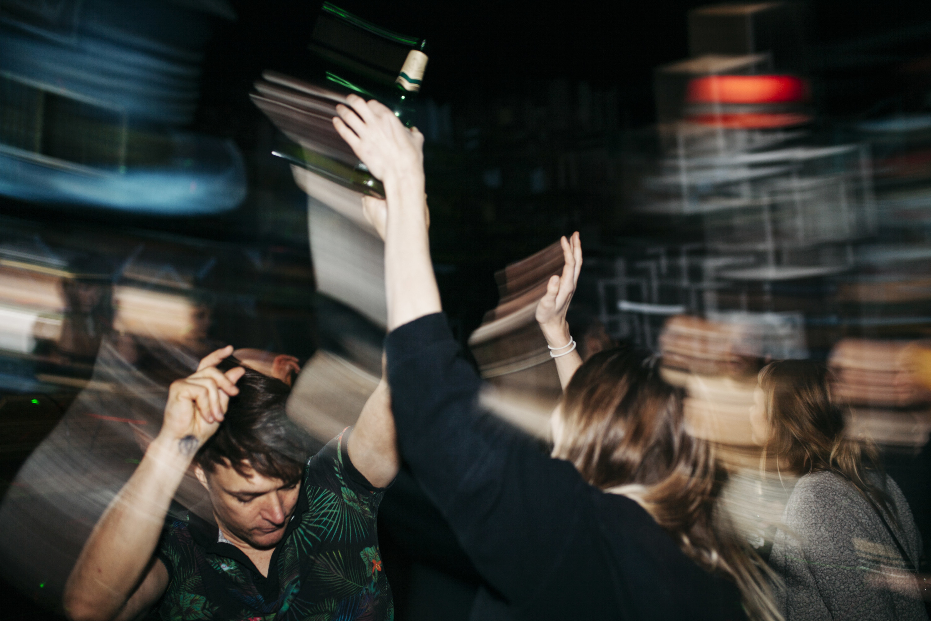 A blurry photo of people dancing at a party in the dark