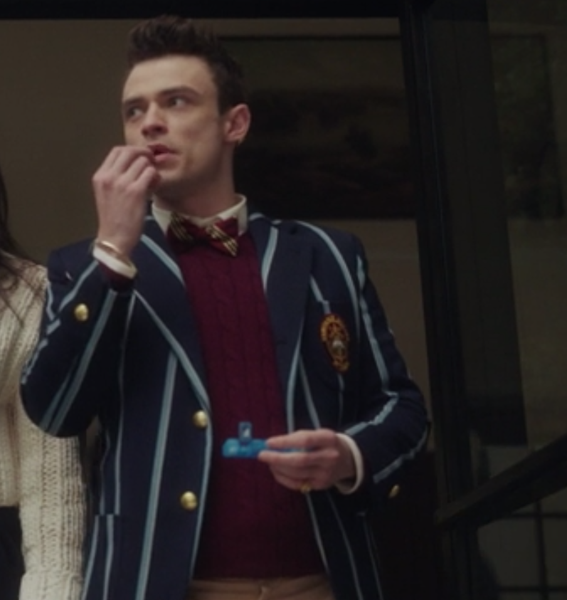 Max wears his pin-striped uniform blazer over a knit sweater and a bow tie that matches the sweater