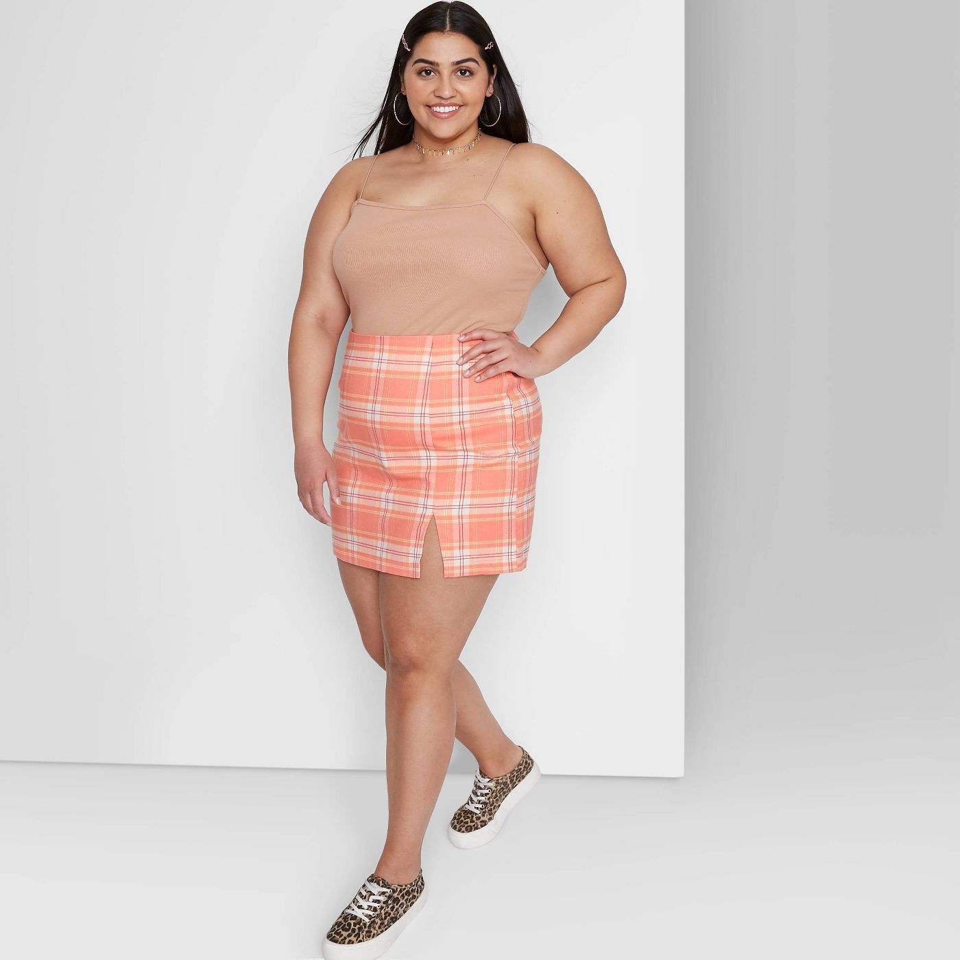 a person in the skirt, which is a coral-pink and white plaid