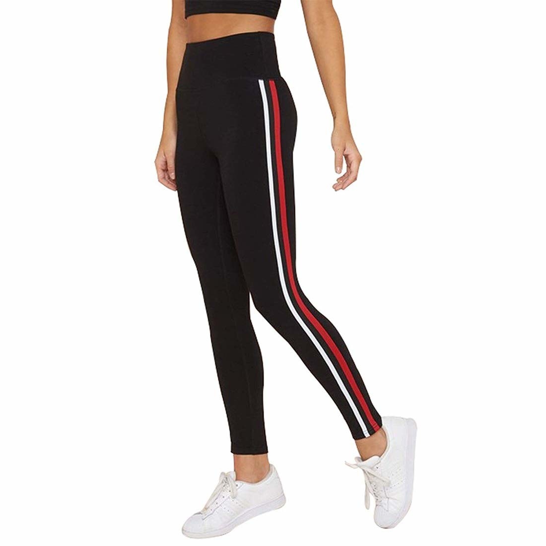 A woman wearing striped stretchy pants with a crop top and shoes
